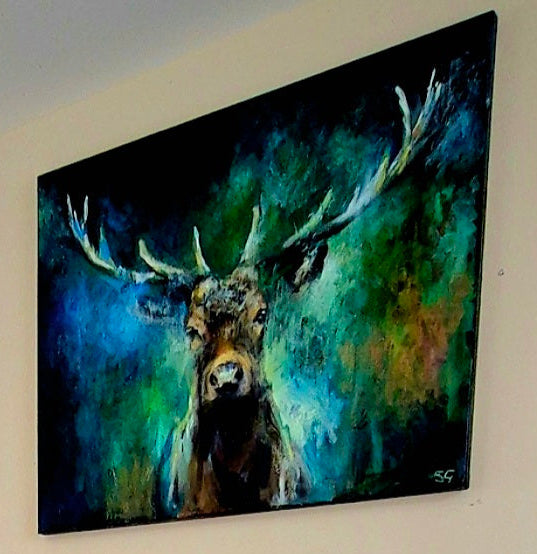 Three dogs in a living room with a large painting of a deer on the wall.